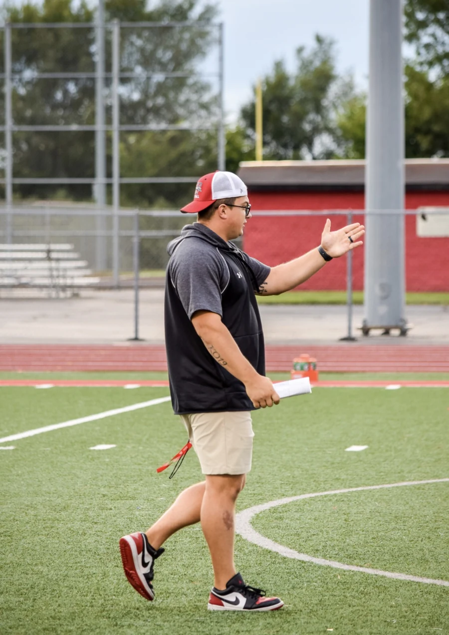 Coach Bartlett giving instructions on the football field.